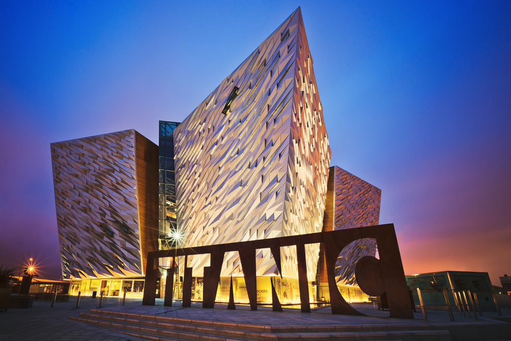 Dusk at the lit-up Titanic Museum which is modern and metal.