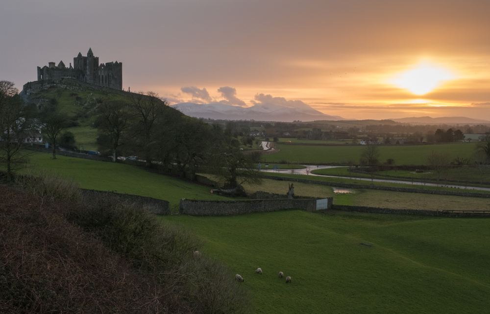 Rock of Cashel at sunset, the castle is on the hill. The article is about the best time to vissit Ireland. 