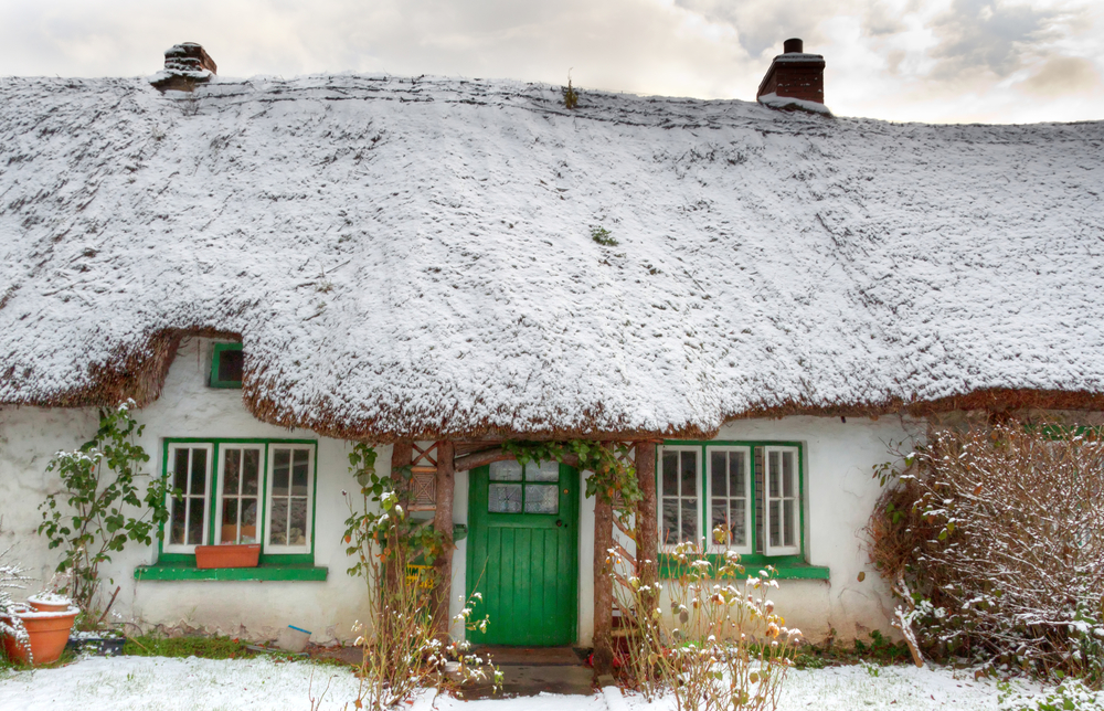 Traditional irish cottage at winter time. The door is green 