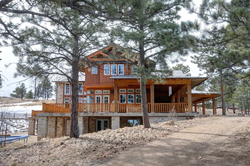 view of the rustic exterior and the surrounding pines of the Luxury Mountain Retreat, one of the best airbnbs in Boulder 