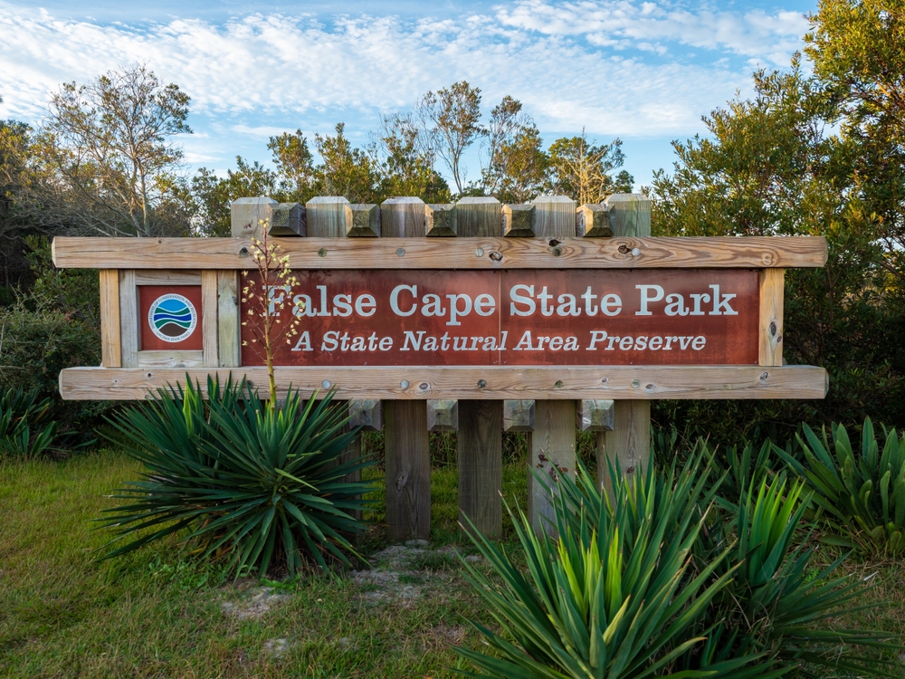 The False Cape State Park welcome signs welcomes guests to the nature preserve, where you can camp pristine in the area, making it one of the top spots for the best beach camping in the USA.  