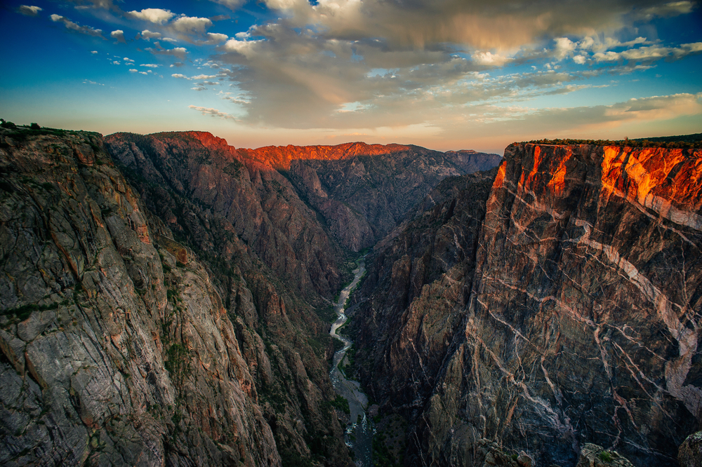 Sunset over the Black Canyon Of The Gunnison National Park with a river at the bottom.