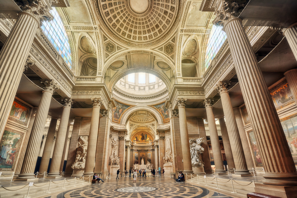 Inside the Pantheon with many columns and a domed ceiling.