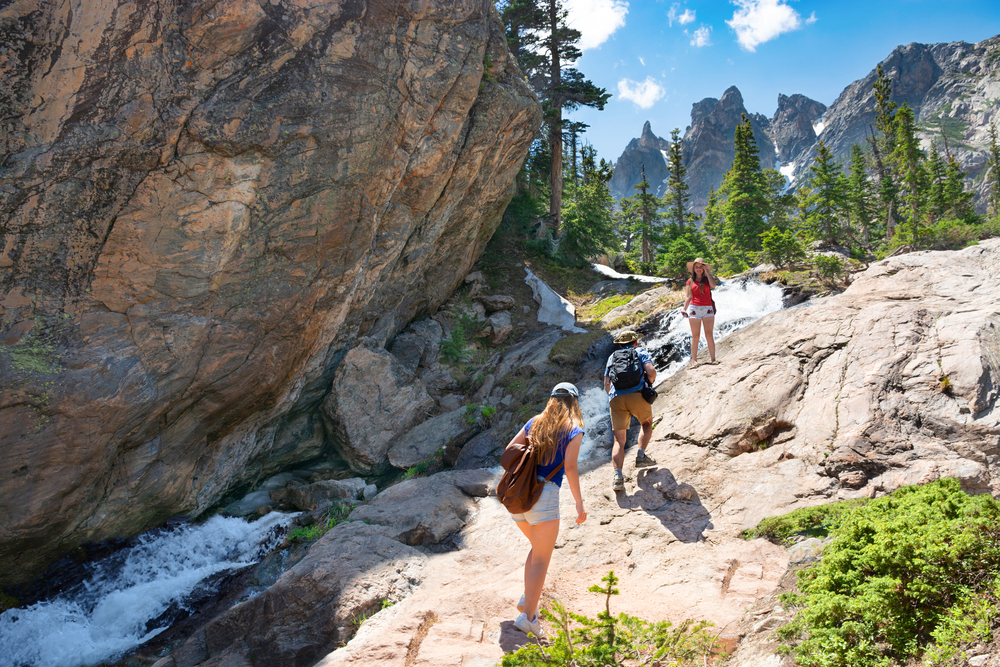 Family hiking along a river in the Rocky Mountains.