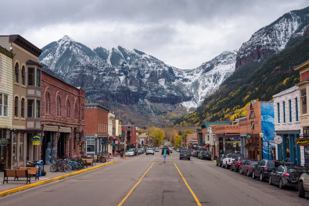Downtown Telluride with historic buildings and snowy mountains in the distance.