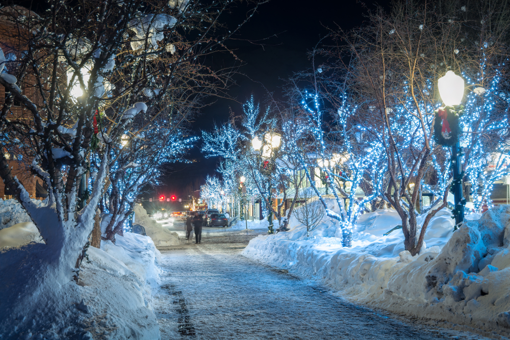 a snow covered lane in Aspen Colorado with blue lights in the trees. This is one of the best christmas towns in the USA 