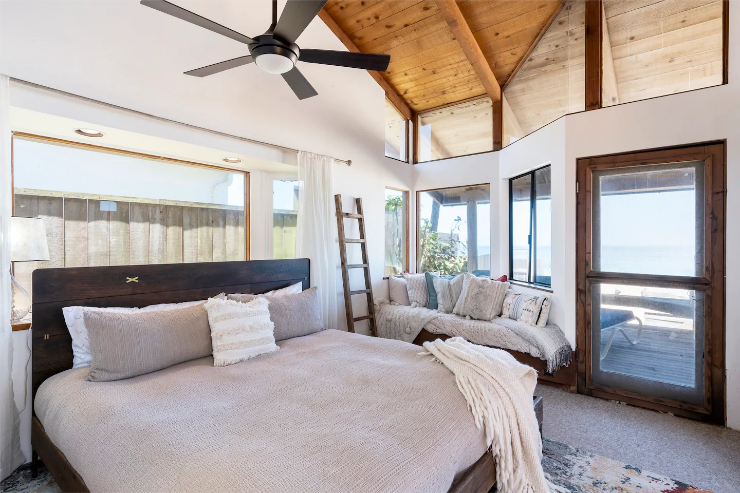 View of a high ceilinged bedroom with view of the ocean 