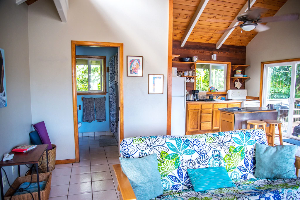 View of the cozy Rocky Point loft kitchen and living room. The space is very bright and decorated with blue colors.