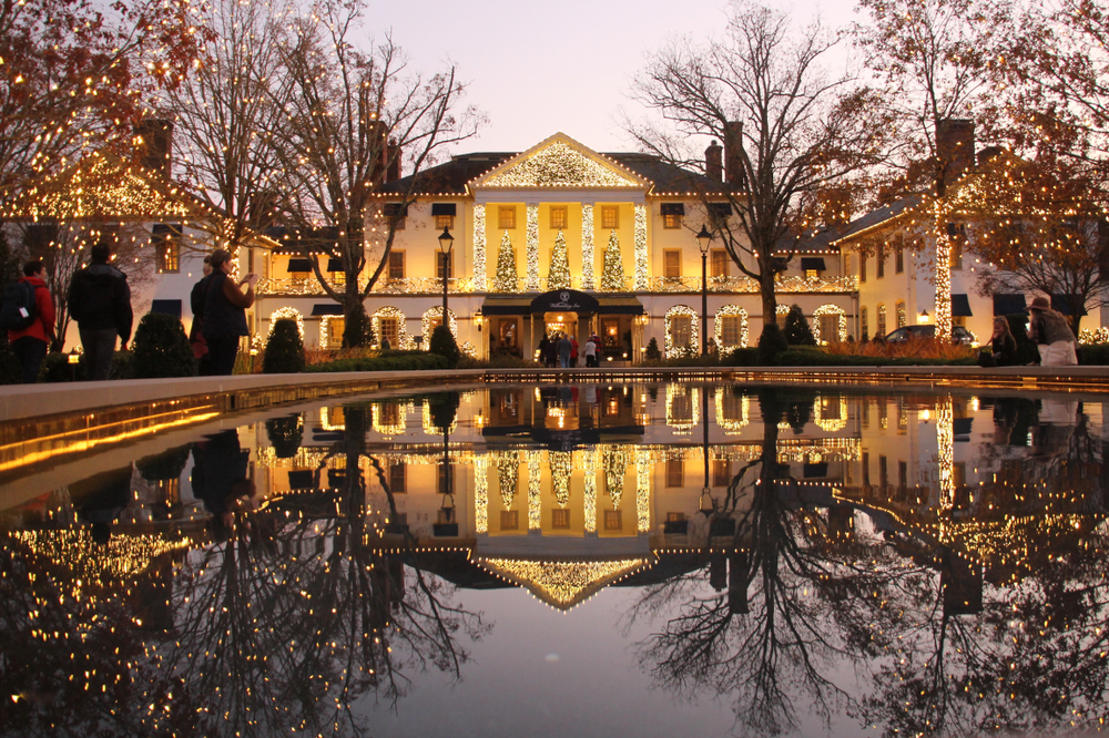 a big home inside Williamsburg VA full of christmas lights and a big reflecting on the lake 