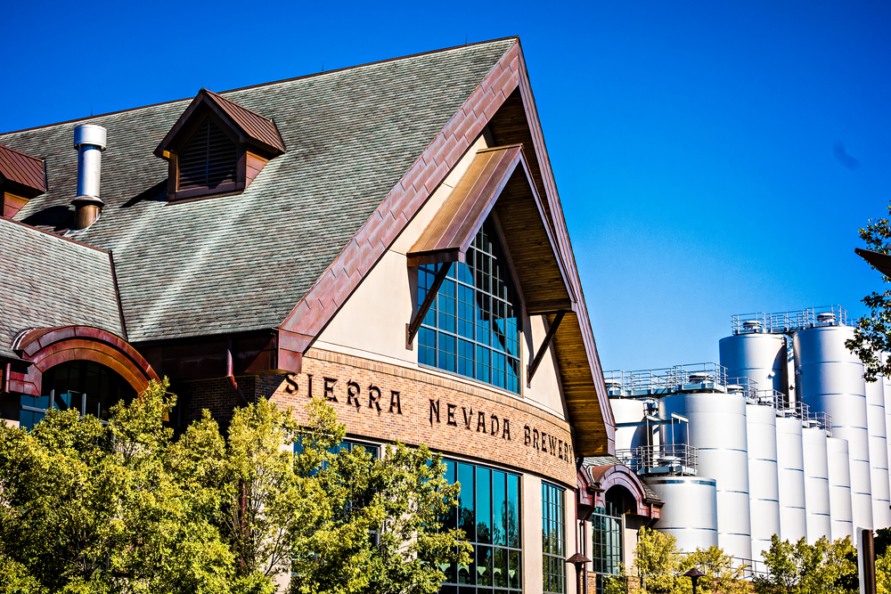 the beautiful Sierra Nevada brewery with blue sky and lots of beer making in the back round 