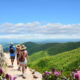 people hiking in asheville north carolina with blue skies and green mountains