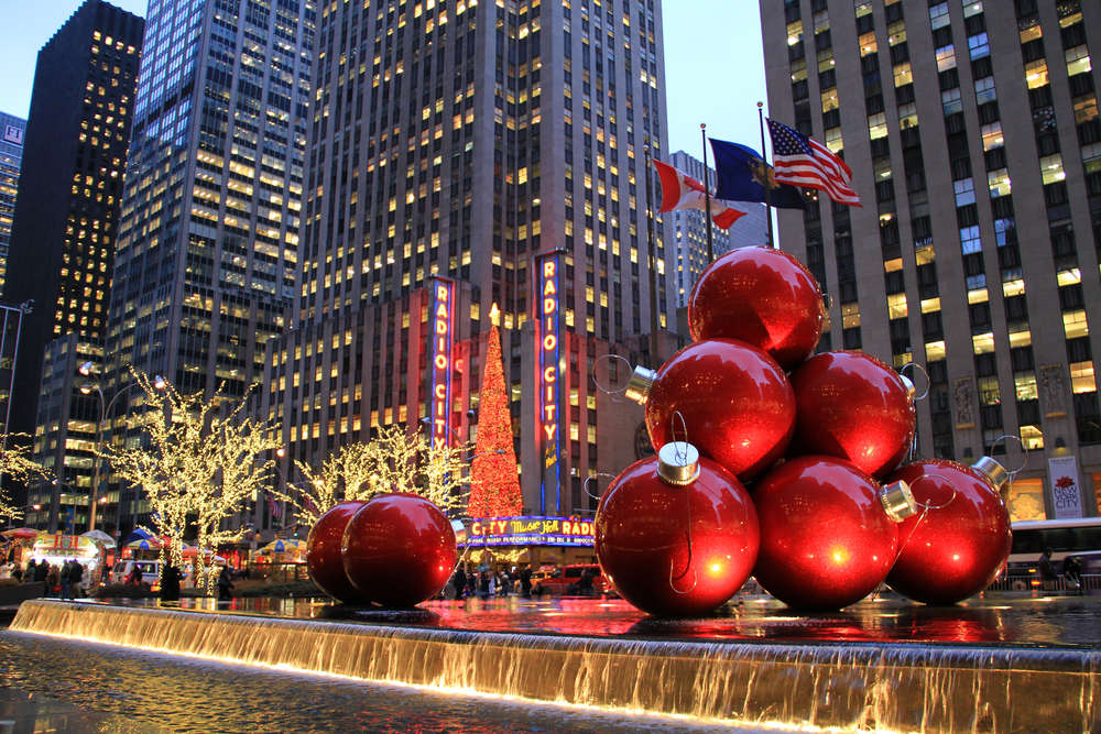 Dusk at a holiday display in New York City with giant red ornaments and lit trees during Christmas in the USA.