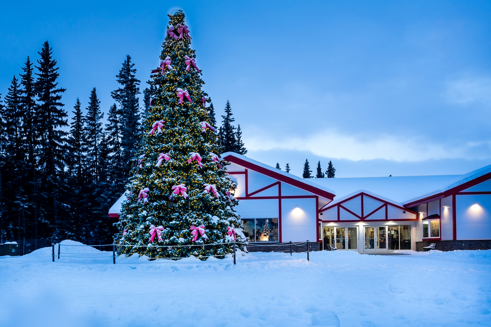 Blue hour in North Pole, Alaska with a tall Christmas tree with bows.