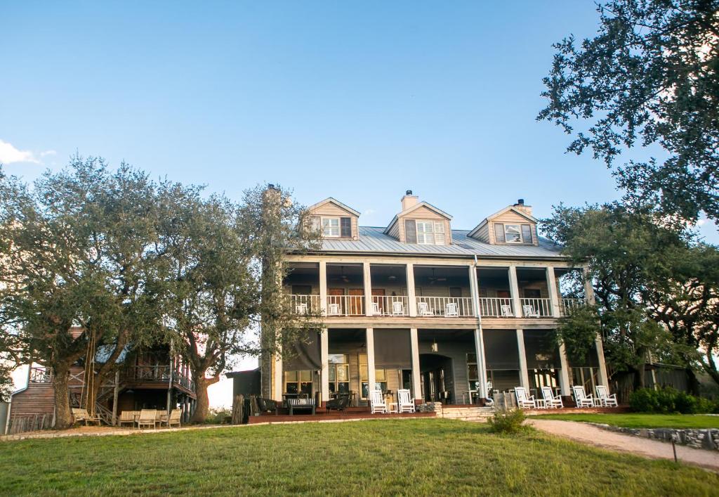 a picture up the hill of the beautiful BNB all inclusive resort in texas, sage hill, with picturesque porch straight from the Notebook! 