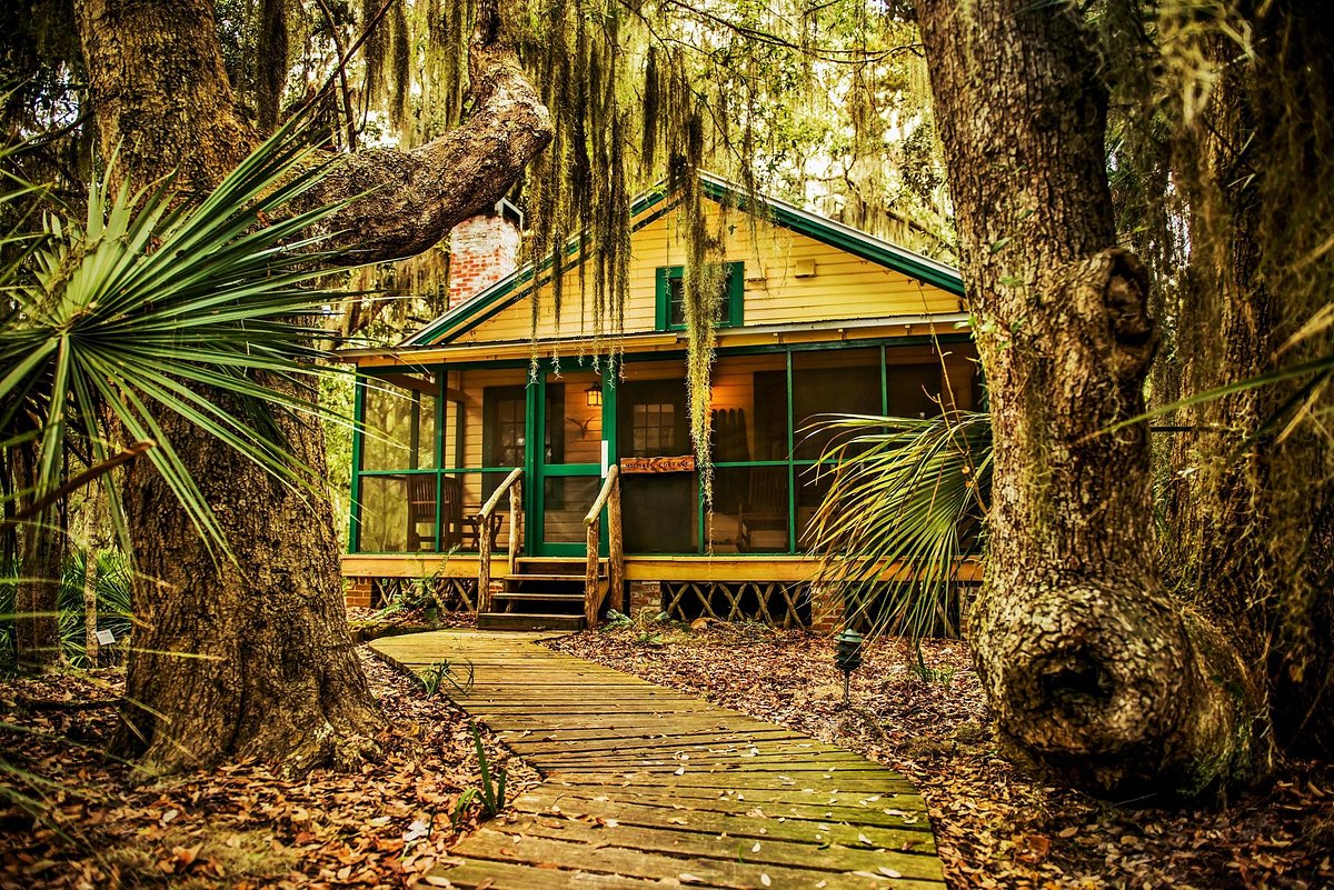 One of the historic cottages at one of the all-inclusive resorts in the south. The cottage is yellow and green with vines and greenary around it.  