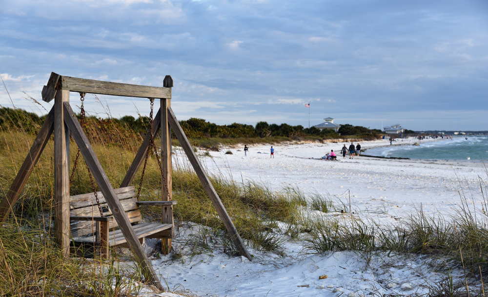 A wooden swing sits on the corner of white sand at one of the most popular beaches in Tampa-- Honeymoon Island. 