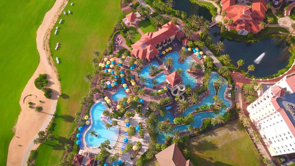 An ariel view of the hotel with water park complex with a lazy river, pools, water slides with golf course lake and resort