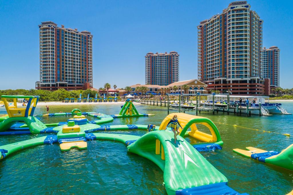 an adventure park set up in the ocean with inflatable pieces