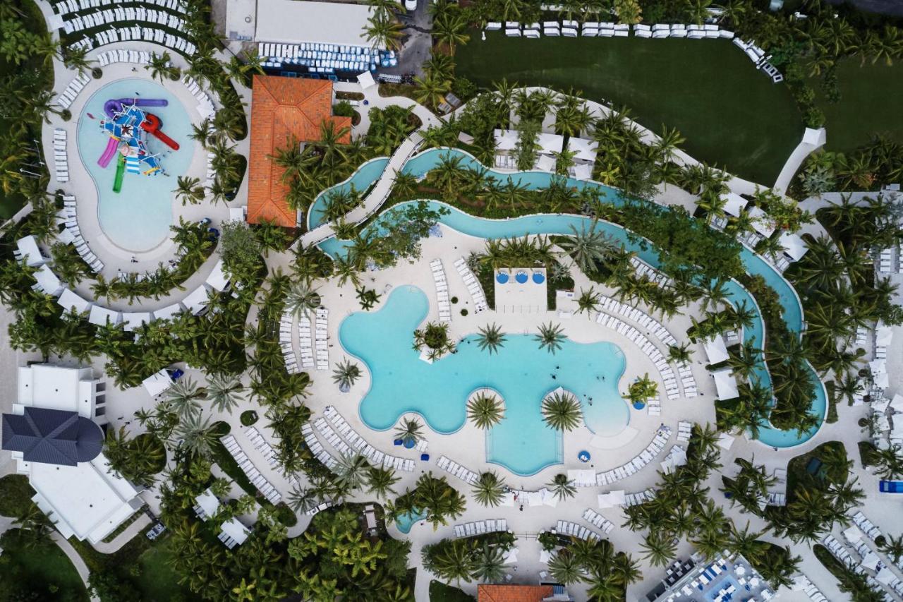 the waterpark is one of the best florida resorts with water parks near miami you can see waterslide complex, lazy river and large pool surrounded by tons of trees