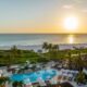 sunset with a pool and ocean in the background at one of the best beachfront resorts at marco island florida