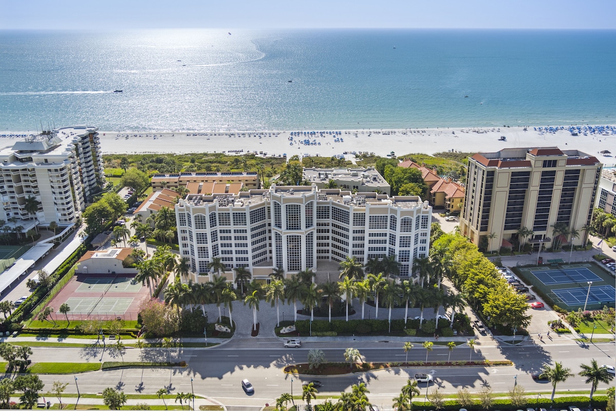 an aerial image of the massive property with view of the road, tennis courts and the big stretch of beach! A great option for the best beach resorts on marco island!