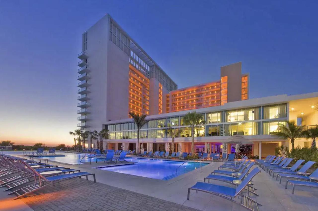 a dark dusk sky with bright lists and a beautiful pool area with plenty of seating!