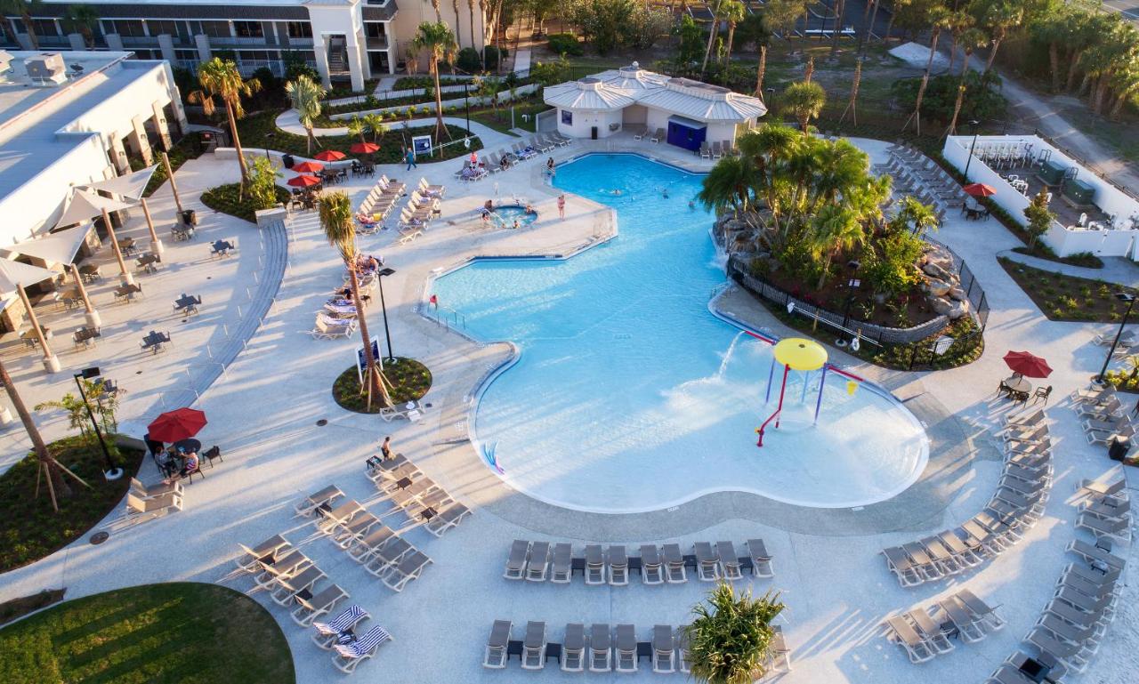 photo from above a pool with small children's waterpark in orlando, lounge chairs and palm trees surround the pool