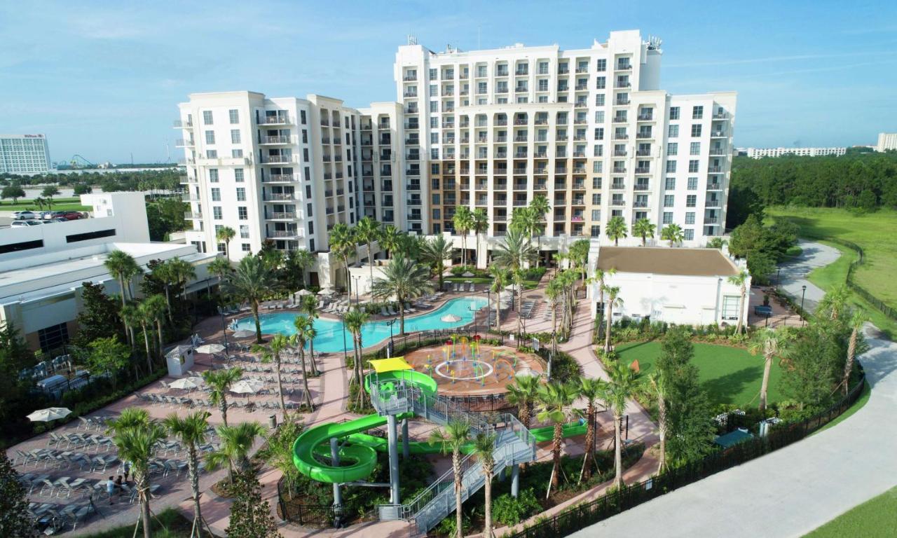 large resort in background, grass to the right, and a pool and waterpark in front of the Orlando water park hotel with water park