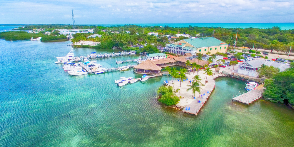 aerial image of bright turquoise waters and green trees of the coastal dock of one of the best small towns in Florida