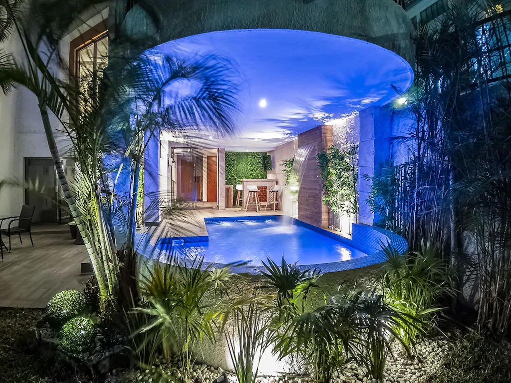 View of the incredible outdoor bar and plunge pool with waterfall of the Camila Residence, one of the most epic Cancun vacation rentals