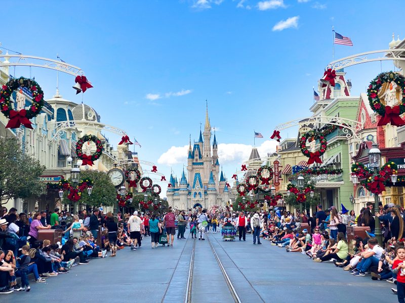 Main Street at Disney World with holiday decorations and the castle in the background.