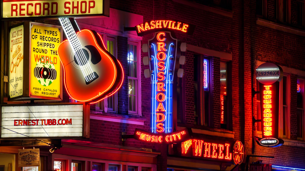 The neon signs lit up on a street in Nashville at night 