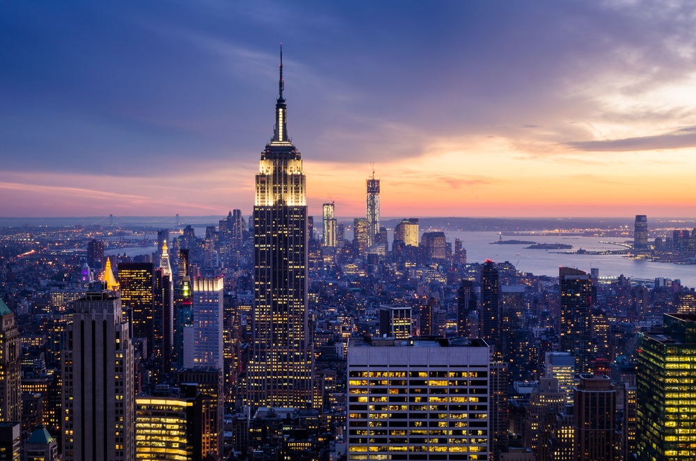 A view of the NYC skyline as the sun is starting to set and the building lights are on one of the best things to do in the usa