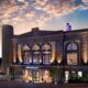 outside of the JW Marriott resort in Savannah a purple lit building with smoke stacks on a sunset evening