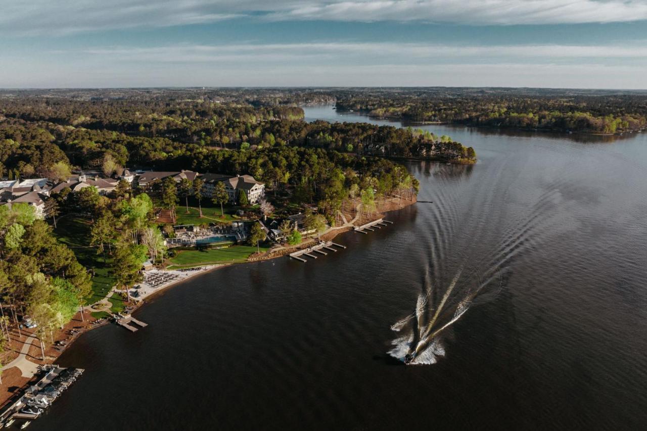 an aerial image of a boat passing in front of a resort with a lot of boat access and a large building with lots of green! A beautiful image of one of the resorts in Georgia