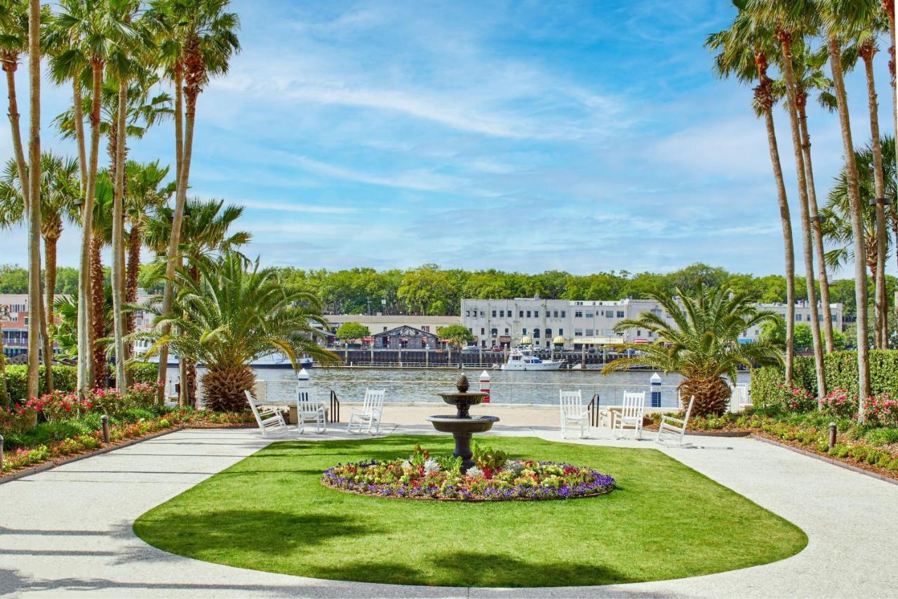 a bright blued sky with palm trees and palm bushes and a courtyard featuring a fountain!