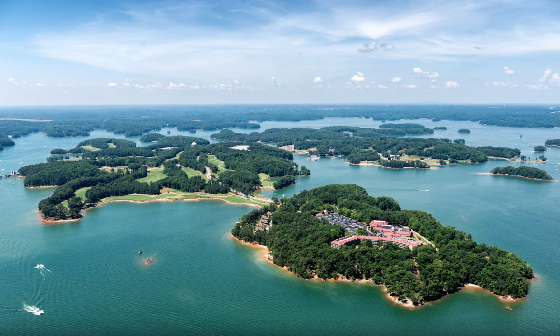 an aerial image of a big red resort and a large golf course on the next cluster of islands!