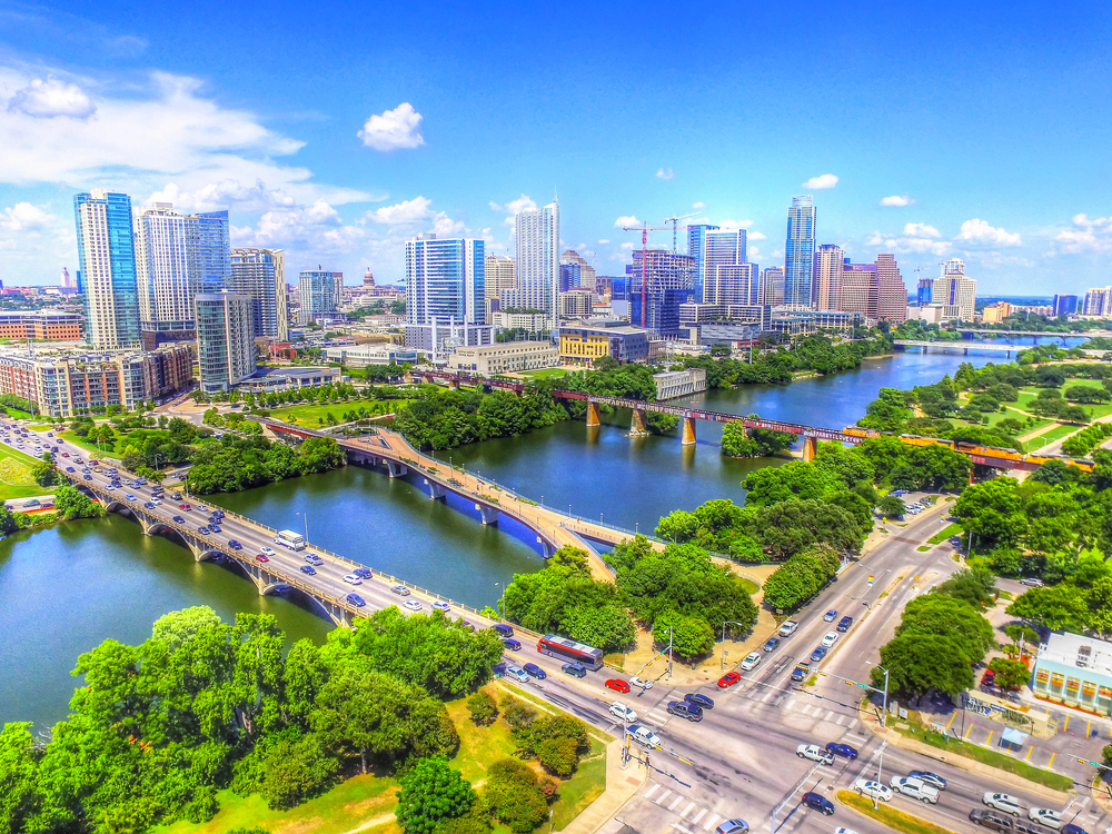 a big bright day in Austin Texas. you can see the pretty river, big buildings and the three bridges that will take you to and from downtown this is one of the best weekend getaways in Texas 