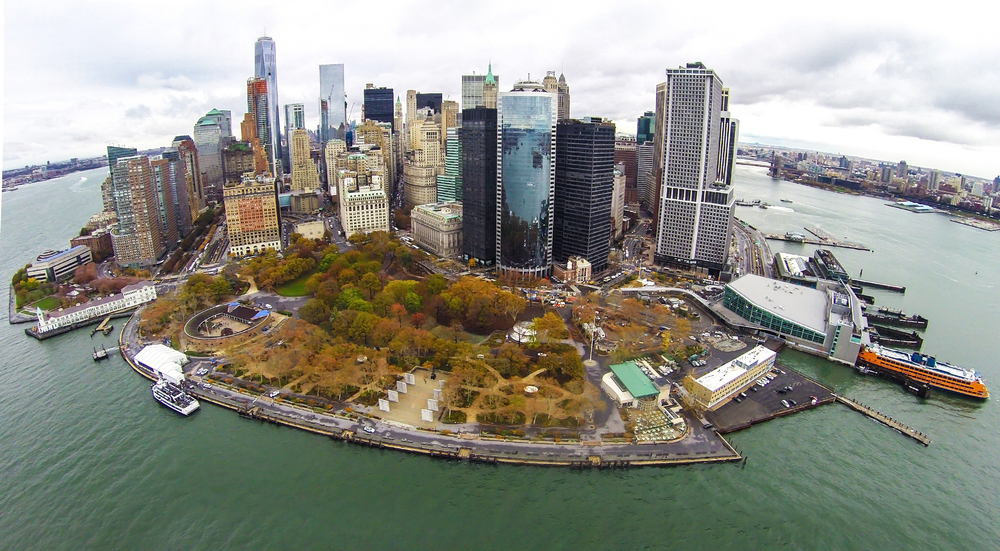 the view of Battery Park from above during the fall. it is located in the center of NY with big buildings in the back and it is also right on the water 