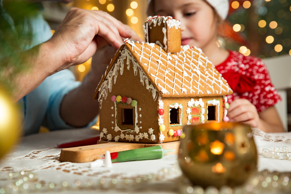 Gingerbread house being decorated by father and daughter at ICE at Gaylord Palms, a must if you are spending Christmas in Florida. 