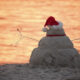 Snowman made of sand with a Santa hat on the beach in Florida.