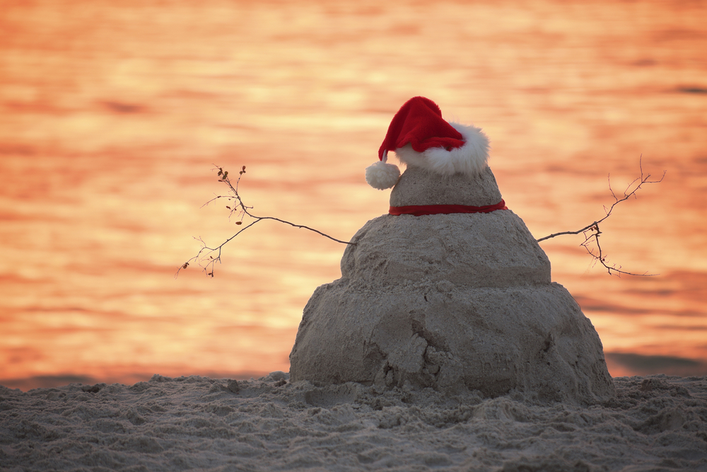 Snowman made of sand with a Santa hat on the beach at sunset in Florida!