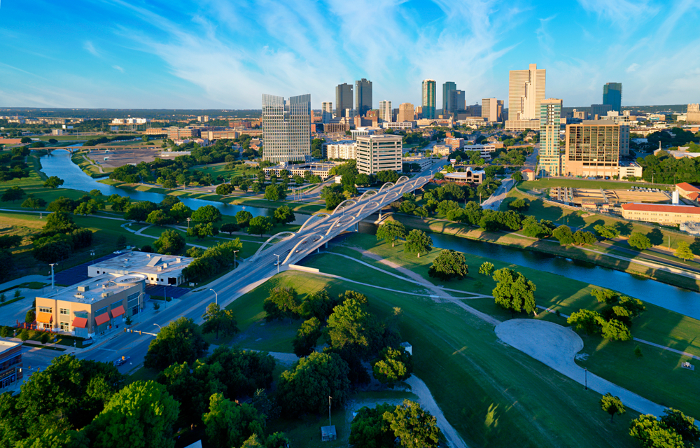 the town of Fort Worth Texas at blue hour. you can see the pretty river and big buildings in the back round