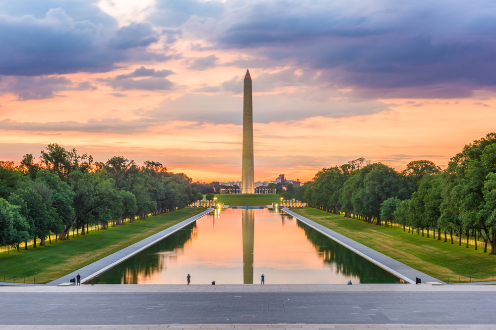the National Mall in Washington DC at sunset with the monument reflecting into the big pond out front