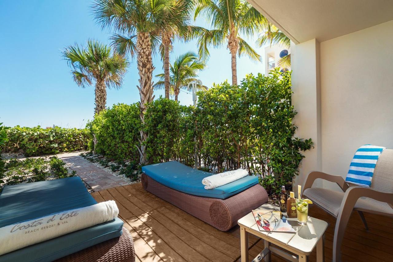 A private walk way at one of the best all inclusive resorts in Florida (Costa D'Este) shows two beach chairs, a private balcony, and easy access to the beach.