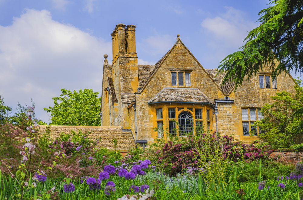 hidcote manor gardens in the english cotswolds, gloucestershire. The picture shows the house surrounded by flowers. 
