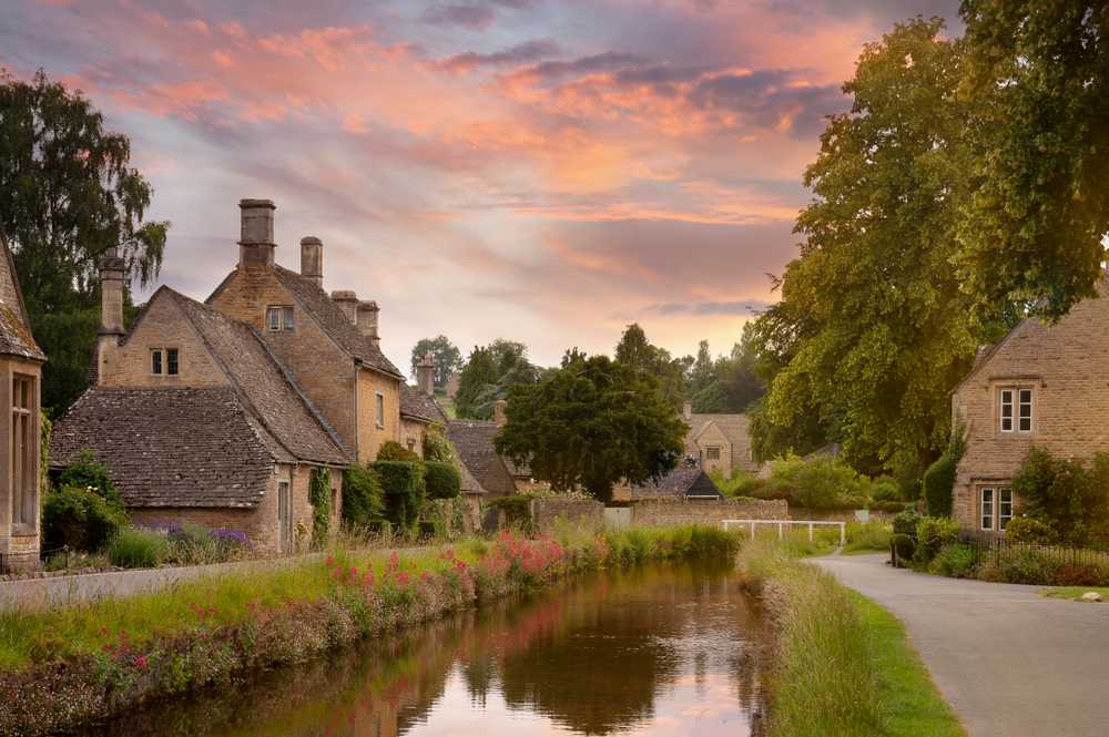 The village of Lower Slaughter showing a river with cottages either side. 