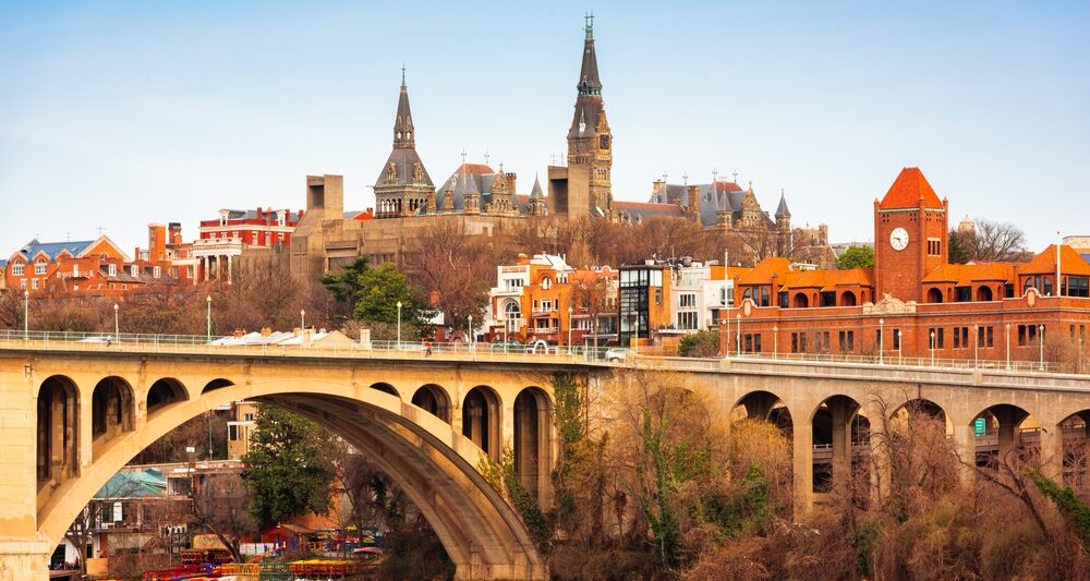 beautiful fall image of the bridge leading into the Georgetown district with lovely terracotta buildings and medieval-like structures on their campus!