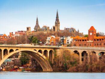 beautiful fall image of the bridge leading into the Georgetown district with lovely terracotta buildings and medieval-like structures on their campus!