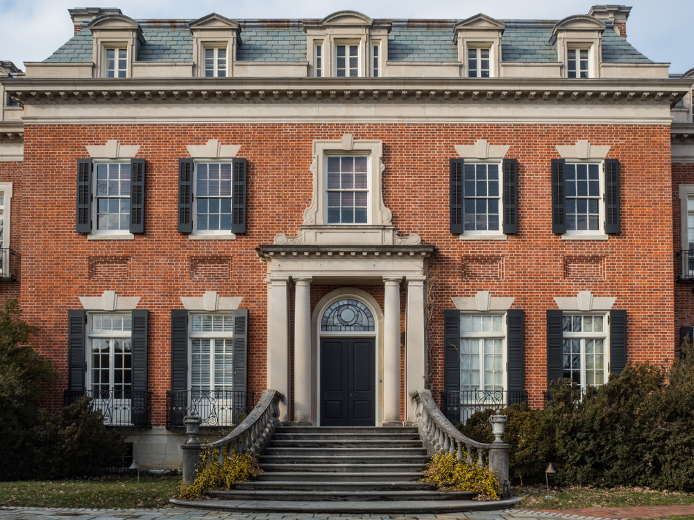 beautiful red brick with classic colonial front of house windows, black shutters and columns